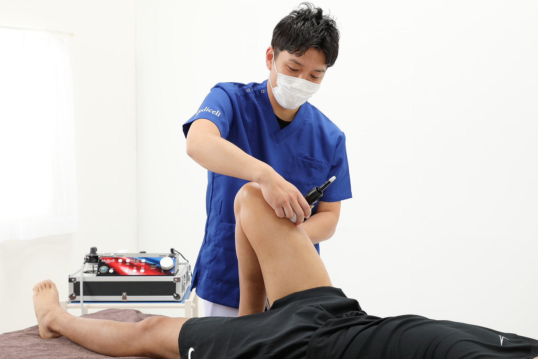 男性スタッフによる専門機器を用いた筋膜リリース施術